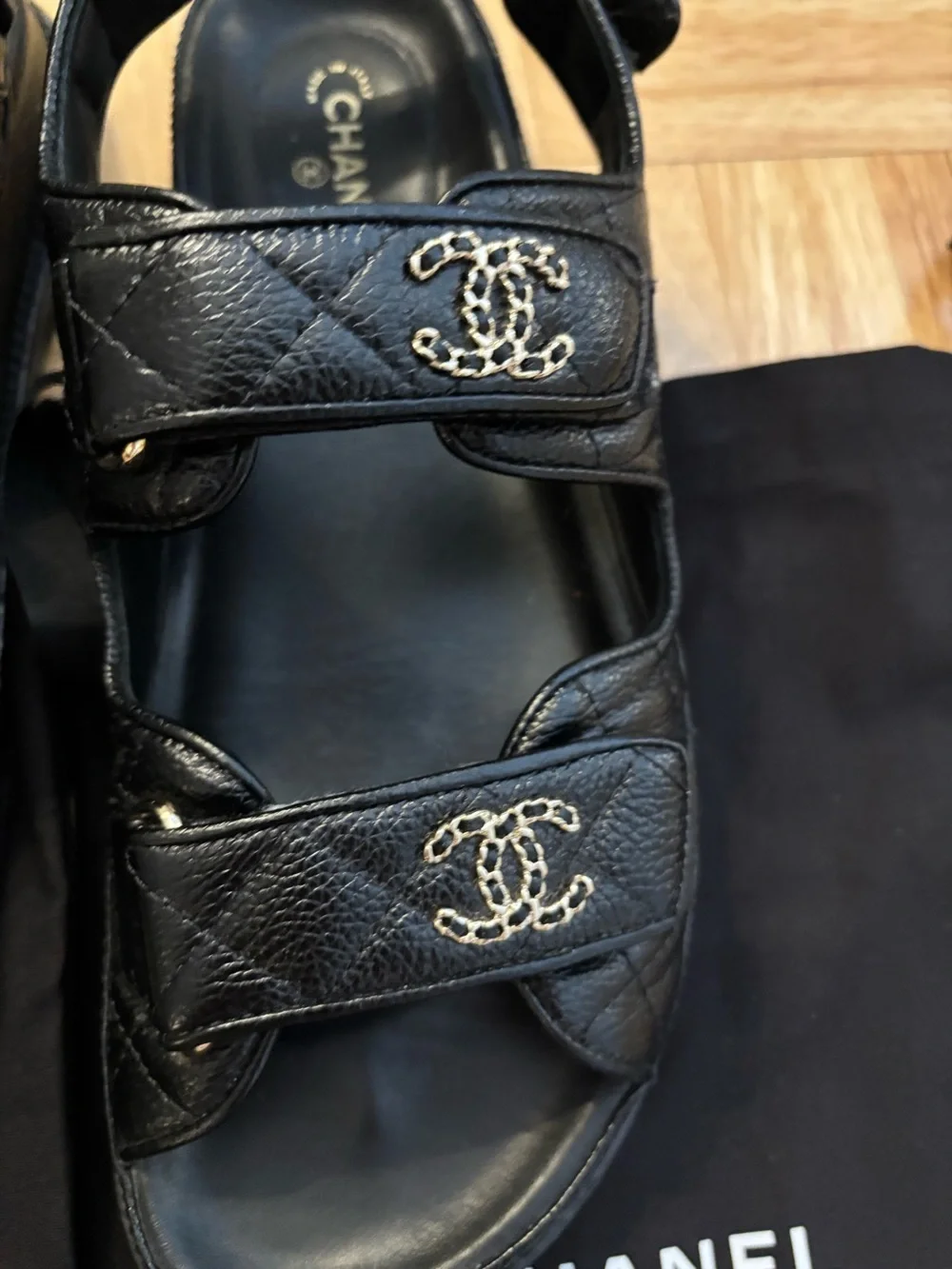CHANEL Dad Black Leather Logo Strap Sandals with Gold CC Hardware.